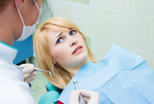 dental patient model looking at the dentist with furrowed brows and a worried look