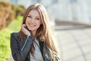 dental implants patient model wearing a leather jacket and smiling