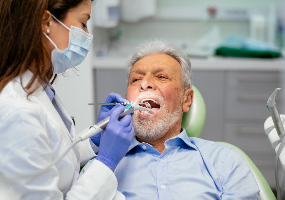 older sedation dentistry patient model laying in a dental char receiving dental work