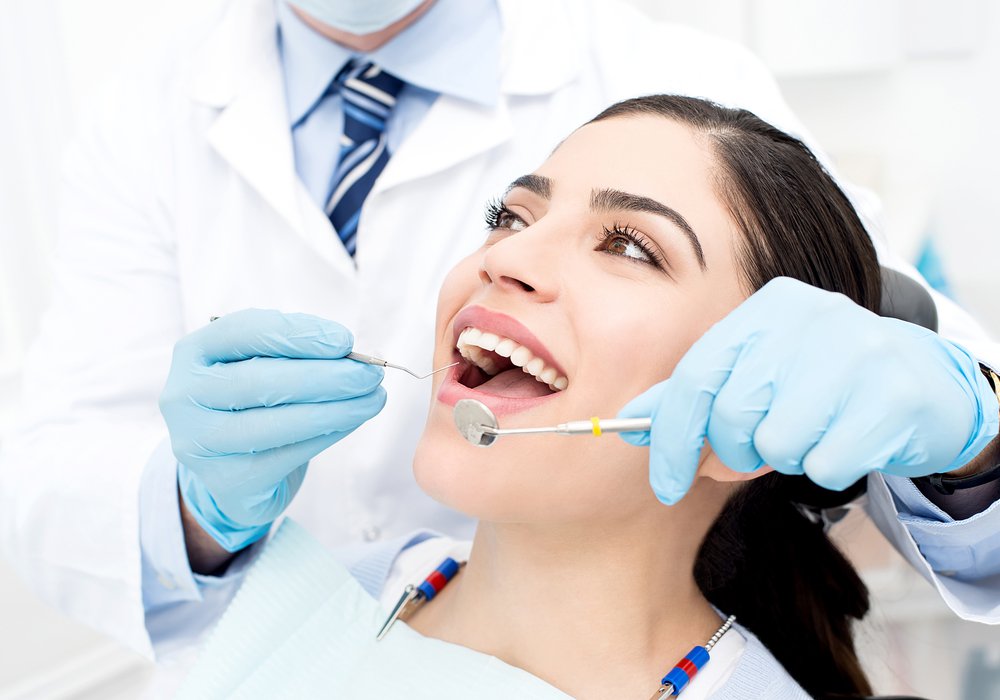 smiling emergency wisdom tooth removal patient model sitting in a dental chair