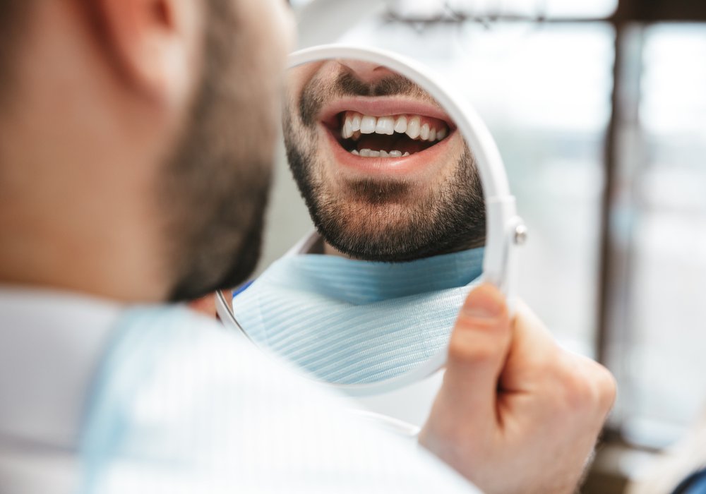 Philadelphia Emergency Dentist patient model smiling while looking in a mirror