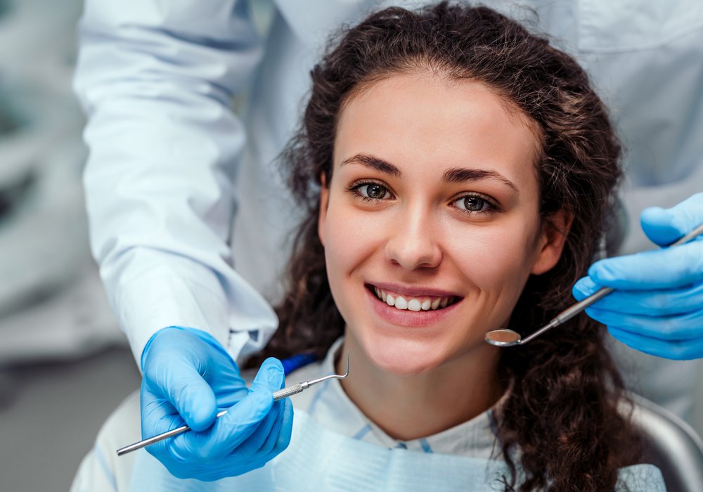 smiling teeth-in-a-day patient model in a dental chair