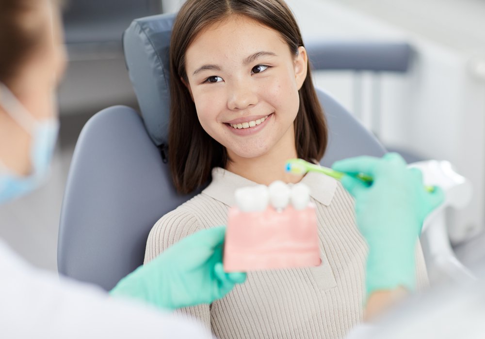 young invisalign patient model receiving a consultation at a dental office with plastic tooth models