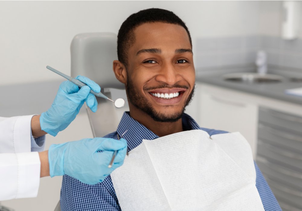 dental crown patient model sitting in a dental chair smiling